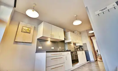 a kitchen with white cabinets and white appliances at Old Town Apt Józefa Street 22 in Kraków