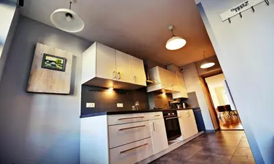 a kitchen with white cabinets and white appliances at Old Town Apt Józefa Street 22 in Kraków