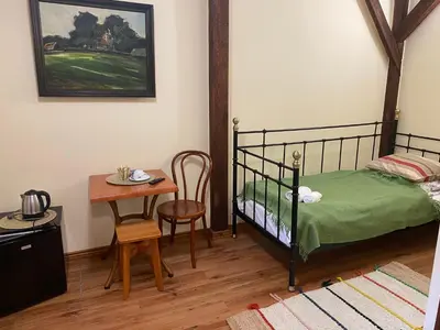 a bedroom with a bed and a small table at Karczma Siedlisko Pokoje Gościnne in Miechów