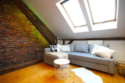 a living room with a couch and a brick wall at Atmospheric Apartment close to Old Town by Rently in Kraków