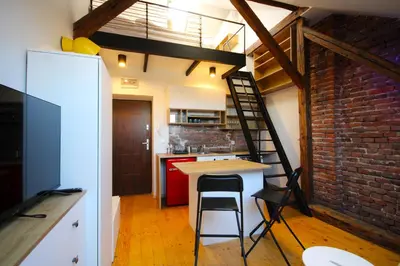 a kitchen with a table and a brick wall at Atmospheric Apartment close to Old Town by Rently in Kraków
