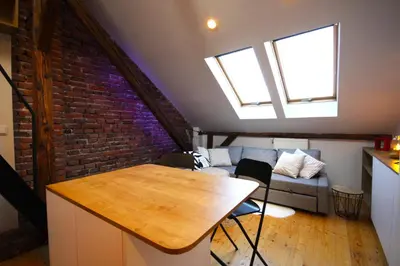 a living room with a table and a brick wall at Atmospheric Apartment close to Old Town by Rently in Kraków