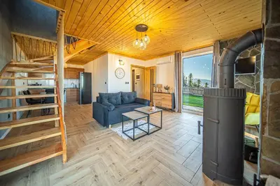 a living room with a blue couch and a wood stove at Osada Golców