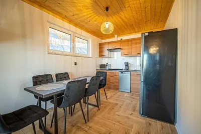 a kitchen and dining room with a table and chairs at Osada Golców