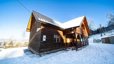 a wooden cabin in the snow with snow on it at Osada Golców