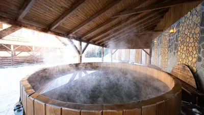a large wooden barrel in a room with snow at Osada Golców