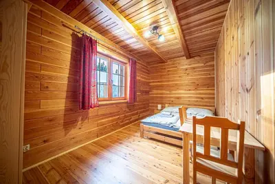 a log cabin bedroom with a bed and a window at Osada Golców