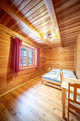 a bedroom with a bed and a table and a window at Osada Golców