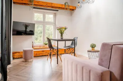 a living room with a table and chairs and a window at Old Town Siemieradzkiego Apartments by Hosty in Kraków