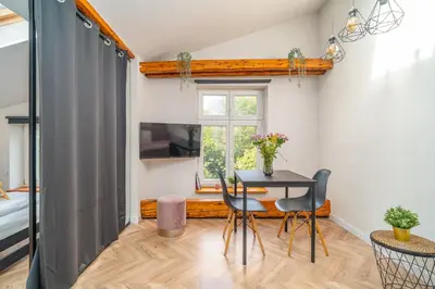 a dining room with a table and chairs and a window at Old Town Siemieradzkiego Apartments by Hosty in Kraków