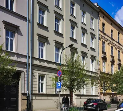 a large building with a parking sign in front of it at Old Town Siemieradzkiego Apartments by Hosty in Kraków