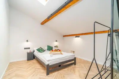 a bedroom with a bed in a white room at Old Town Siemieradzkiego Apartments by Hosty in Kraków