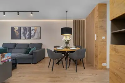 a living room with a couch and a table and chairs at Air Conditioned Apartment in Cracow with Parking and Desk by Noclegi Renters in Kraków