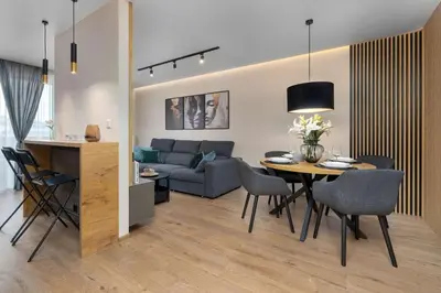 a living room with a couch and a table and chairs at Air Conditioned Apartment in Cracow with Parking and Desk by Noclegi Renters in Kraków