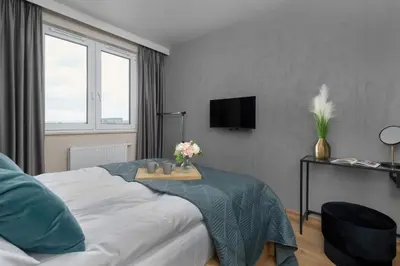 a bedroom with a bed with a table with flowers on it at Air Conditioned Apartment in Cracow with Parking and Desk by Noclegi Renters in Kraków