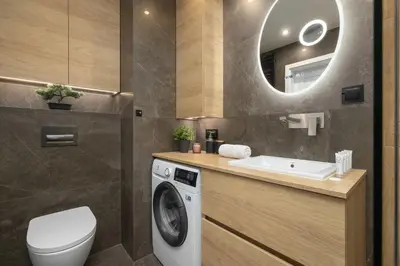 a bathroom with a washing machine and a sink at Air Conditioned Apartment in Cracow with Parking and Desk by Noclegi Renters in Kraków