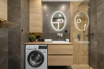 a bathroom with a washing machine and a sink at Air Conditioned Apartment in Cracow with Parking and Desk by Noclegi Renters in Kraków
