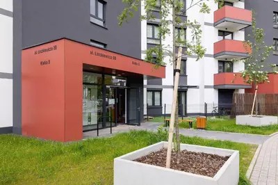 a tree in a pot in front of a building at Air Conditioned Apartment in Cracow with Parking and Desk by Noclegi Renters in Kraków