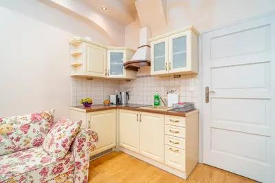 a kitchen with white cabinets and a couch in a room at Kraków Centrum Free Parking 5 min do Rynku in Kraków