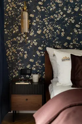 a bedroom with a bed with a floral wallpaper at Soho Residence Kraków by Downtown Apartments in Kraków