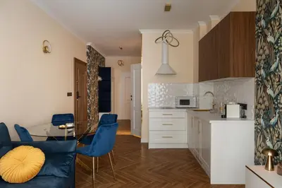 a kitchen with blue chairs and a table at Soho Residence Kraków by Downtown Apartments in Kraków