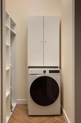 a kitchen with a dishwasher and a white cabinet at Soho Residence Kraków by Downtown Apartments in Kraków