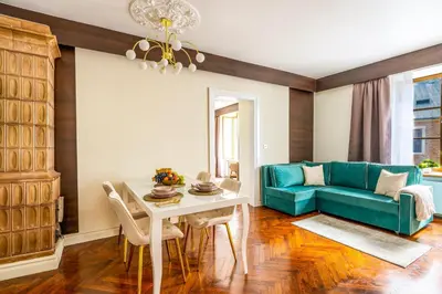 a living room with a blue couch and a table at Main Square Prestige Suites by Staymoovers in Kraków