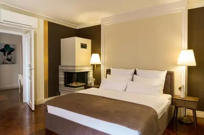 a bedroom with a large bed and a fireplace at Main Square Prestige Suites by Staymoovers in Kraków