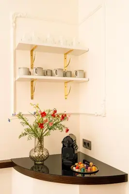 a table with a vase of flowers and a plate of food at Main Square Prestige Suites by Staymoovers in Kraków