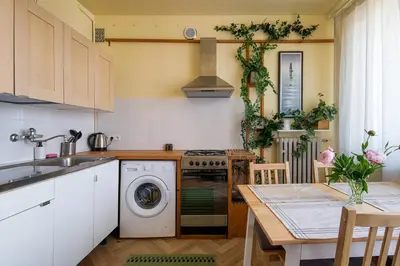 a kitchen with a washing machine and a table at Spacious cental treasure in Kraków
