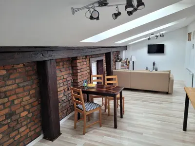 a dining room with a table and chairs next to a brick wall at Golden Middle Point - best location in Krakow in Kraków