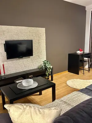 a living room with a tv on a brick wall at Modern Apartament in Kraków's Urban District in Kraków