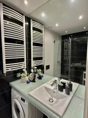 a bathroom with a sink and a washing machine at Modern Apartament in Kraków's Urban District in Kraków