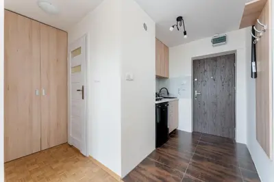 a kitchen with white walls and a wooden door at Czepca Quiet Corner Studio by BookingHost in Kraków