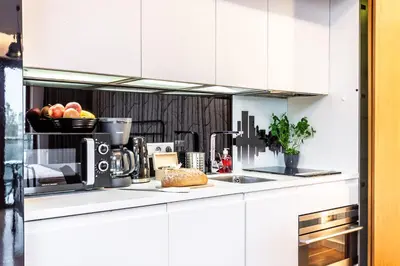 a kitchen with white cabinets and a counter top at ShortStayPoland Grzegórzecka C6 in Kraków