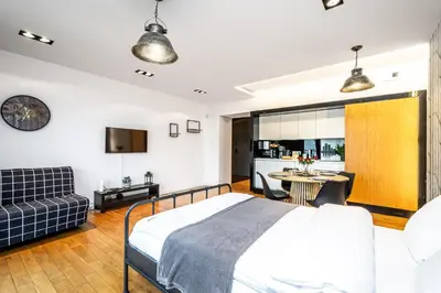 a bedroom with a bed and a living room at ShortStayPoland Grzegórzecka C6 in Kraków