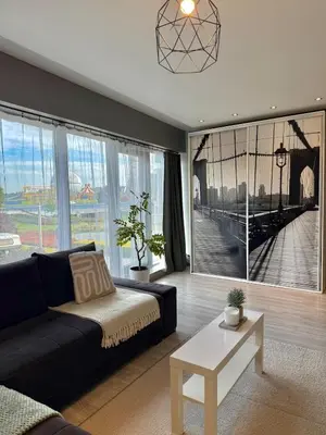a living room with a couch and a large window at Cozy Kraków Escape - Wawel Castle - ICE Centre in Kraków