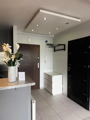 a room with a counter with a vase of flowers at Cozy Kraków Escape - Wawel Castle - ICE Centre in Kraków