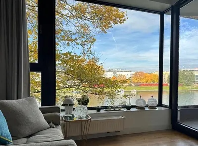 a living room with a large window looking out at the water at Riva Verona Apartment 86 in Kraków