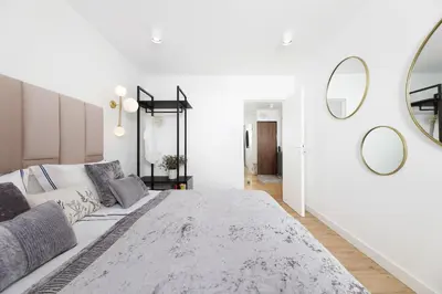 a white living room with a large bed and mirrors at Riva Verona Apartment 86 in Kraków