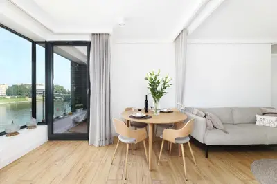 a living room with a table and a couch at Riva Verona Apartment 86 in Kraków