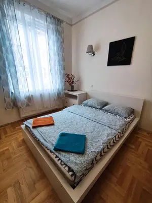 a bedroom with a bed with blue sheets and a window at Krakow City Stay Home in Kraków