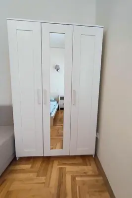 a white closet with a mirror in a room at Krakow City Stay Home in Kraków