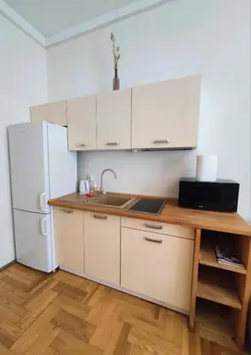 a kitchen with white cabinets and a white refrigerator at Krakow City Stay Home in Kraków