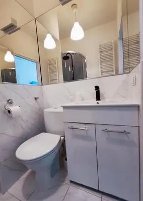a white bathroom with a toilet and a sink at Krakow City Stay Home in Kraków