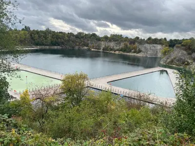 a large pool of water with a bridge over it at Zakrzówek Apartament z Jacuzzi in Kraków