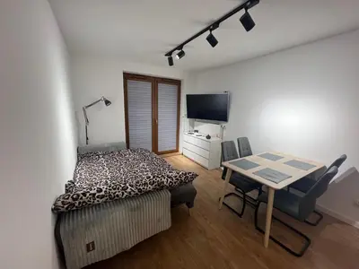 a bedroom with a table and a bed and a desk at Zakrzówek Apartament z Jacuzzi in Kraków