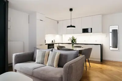 a living room with a couch and a kitchen at Native Apartments Kościuszki 39I14 in Kraków