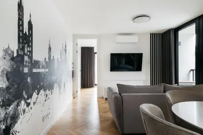 a living room with a couch and a tv on a wall at Native Apartments Kościuszki 39I14 in Kraków