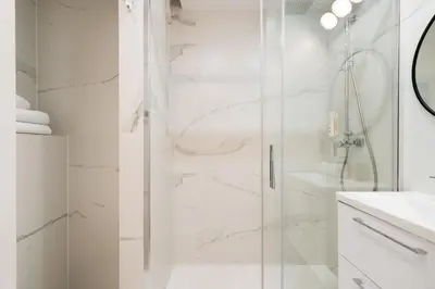 a white bathroom with a shower and a sink at Native Apartments Kościuszki 39I14 in Kraków